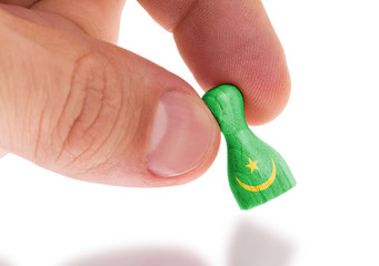 Hand holding wooden pawn, flag painting, selective focus