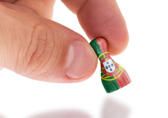 Hand holding wooden pawn, flag painting, selective focus