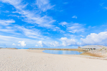 Fototapeta na wymiar Sandy beach with a bridge in Okinawa