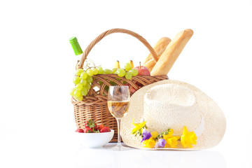 picnic basket with bottle of wine,fruits, bread and summer hat