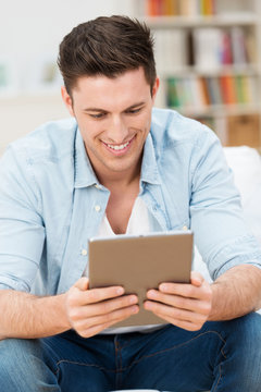 mann liest zuhause am tablet-pc