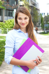 Studentin auf dem Campus lächelt zur Kamera