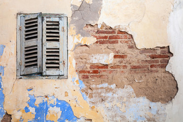 Grunge damaged brick wall with closed window. Background texture