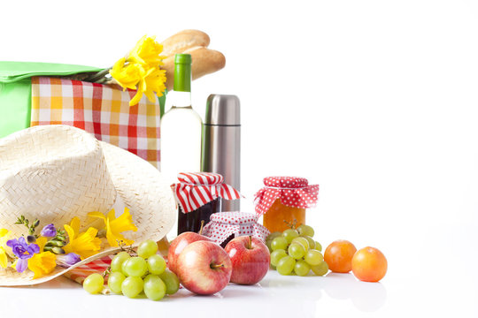 picnic basket with bottle of wine,fruits, bread and summer hat 