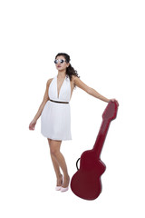 Attractive female wearing sunglasses posing with guitar