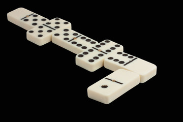 white line of dominoes isolated on a black background