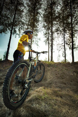 Naklejka premium young man and mountain bike on jungle track use for sport activi