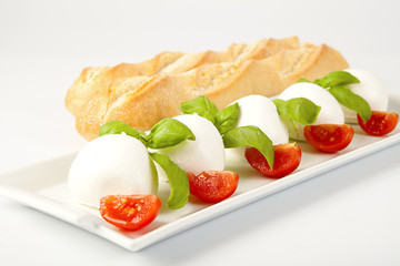 Antipasto italiano di mozzarelle fresche con pomodori e basilico