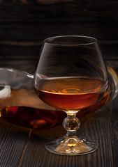Glass of Cognac  brandy on a dark wooden background