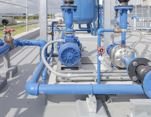 Water pump station centrifugal type including with electric motor, pipe, pipeline, valve control and power cable place on roof deck. Used to control water in water cooling system of industry process. © DifferR