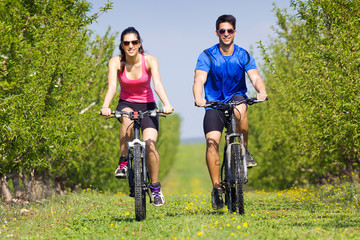 Fototapeta premium Happy young couple on a bike ride in the countryside
