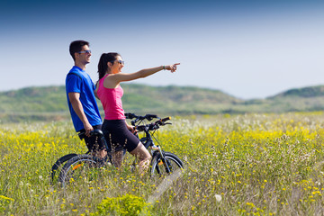 Happy young  couple on a bike ride in the countryside