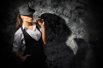Woman with cigar on grey wall