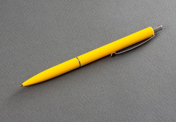 Yellow pen on a gray background.