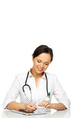 Fototapeta premium Young positive brunette doctor woman taking notes on tablet pc