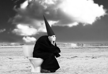 Strange person sits on the toilet and thinks in the desert