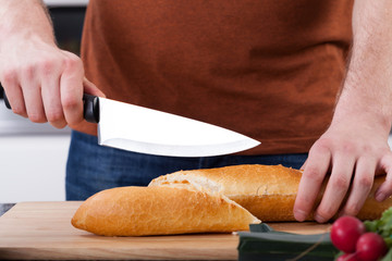 Close-up of hands cutting bread