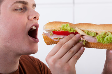 Teenager biting sandwich