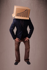 Young man gesturing with a cardboard box on his head with diagra
