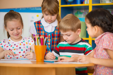 Two cute little girls drawing at school