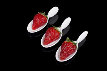 three strawberries in faience spoons