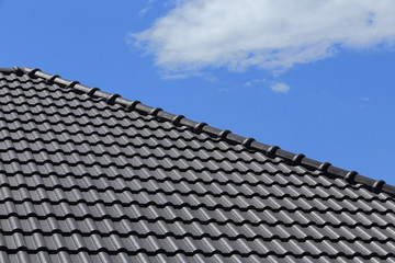 black tiles roof on a new house with blue sky