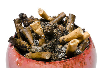 A pile of cigarette butts in old, rusty, red ashtray