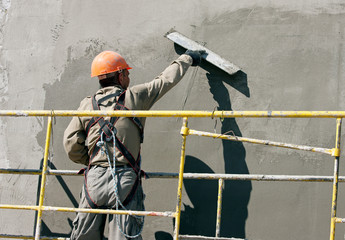 Plasterer worker during finishing facade works