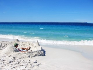 Fototapeta na wymiar A man in his private sand castle