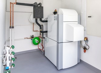 A boiler room with a heating oil warm water system and pipes