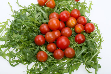 Heap of ruccola leaves and cherry tomatoes