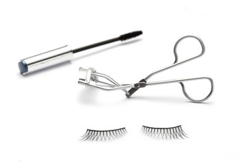 fake false eyelash with eyelash curler and mascara on white