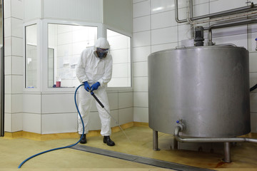 worker ,high pressure washer,  cleaning floor in plant