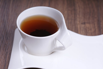 Чашка чая на блюдце на деревянном столе