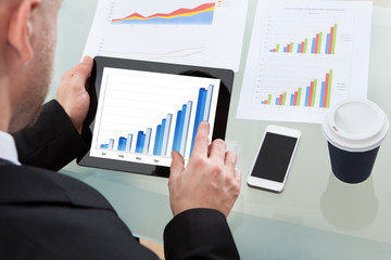Businessman analyzing a graph on a tablet