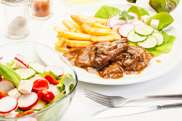 Pork chop with sauce, mushrooms and chips