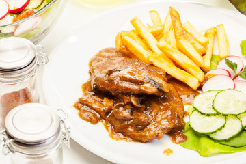 Pork chop with sauce, mushrooms and chips