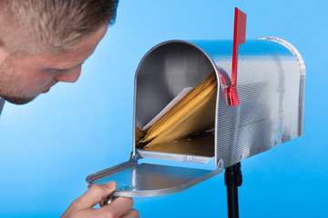 Naklejka premium Man opening his mailbox to remove mail