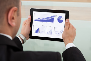 Businessman Checking The Stock Market On Digital Tablet