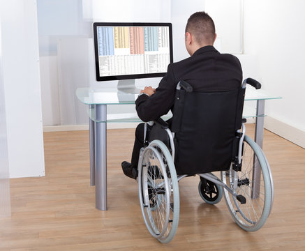 Businessman On Wheelchair Using Computer