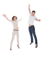 Couple In Casuals Jumping Over White Background