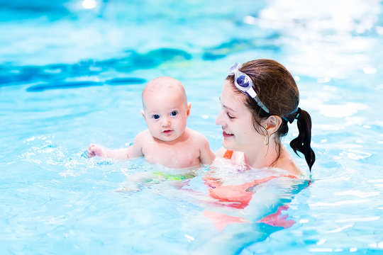 Little baby enjoying swimming lesson in the pool with his mother