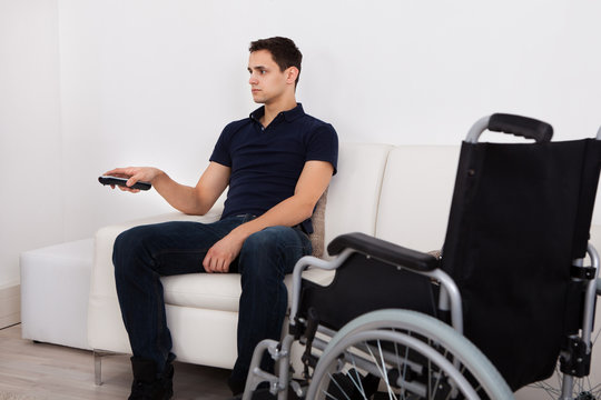 Handicap Man Using Remote Control While Watching Television