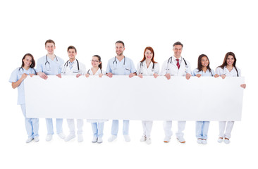 Large group of doctors and nurses with a banner