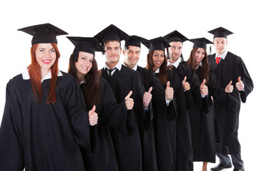 Graduate students standing in row showing thumbs up