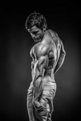 Fototapeta na wymiar Strong Athletic Man Fitness Model posing back muscles and tricep