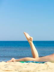 Summer vacation. Legs of sunbathing girl on beach