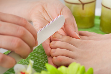 Beautician Filing Nails Of Woman