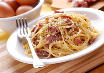 spaghetti alla carbonara con ingredienti intorno