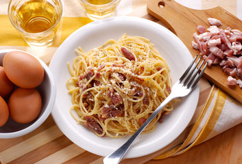 spaghetti alla carbonara con ingredienti intorno
